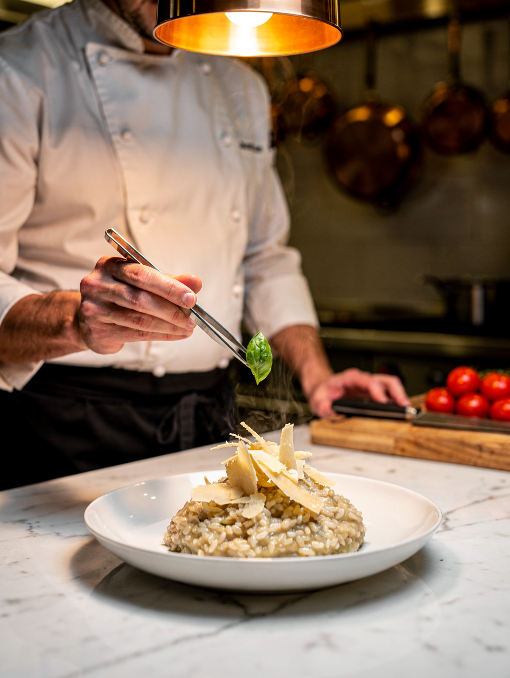 Chef delicately garnishing handmade ravioli with micro herbs